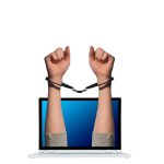 ruke izlaze iz laptopa zavezane lisicama